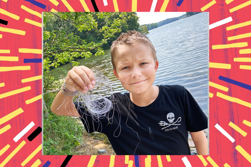boy in black shirt holding ball of tangled plastic in front of a body of water