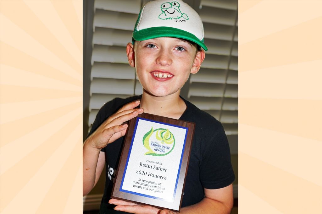 boy with white and green hat holding an award plaque